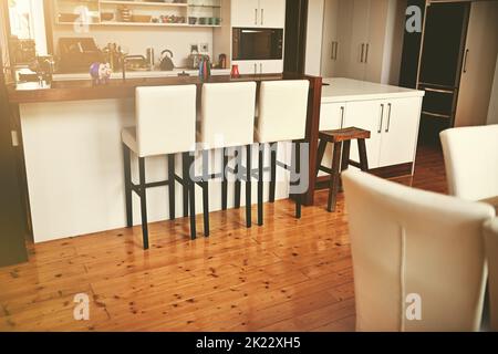Modern done right. Open plan kitchen area in a modern minimalist style home. Stock Photo