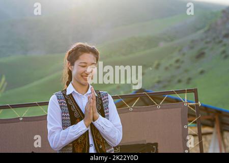 Bishkek province, Kyrgyzstan - April 28, 2018: portrait of a girl in traditional dresses dancing local music in the kyrgyz countryside Stock Photo