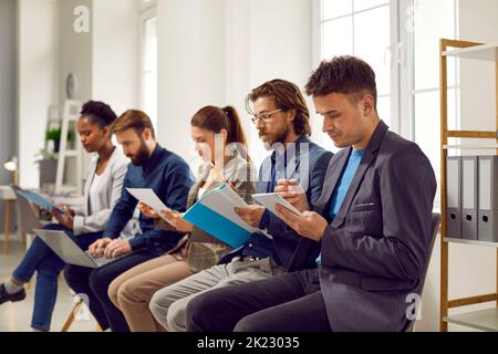 Serious focused business people write down information on business training in office. Stock Photo