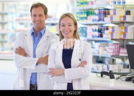 Working hand in hand with doctors to ensure your health. Portrait of two pharmacists standing at the prescription counter. Stock Photo