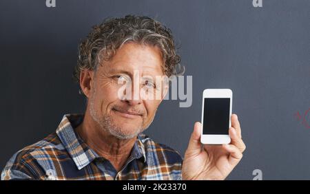 My hand-held personal assistant. A portrait of a happy mature man showing his new smartphone. Stock Photo