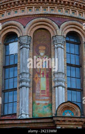 A fragment of the wall of an Orthodox church with the icon of St. Nicholas the Wonderworker painted on it. Stock Photo