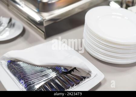 Clean plates, glasses and cutlery on white table. Stock Photo