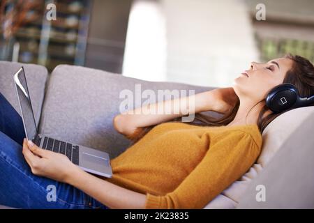 Her favorite pastime. An attractive young woman listening to music while napping. Stock Photo