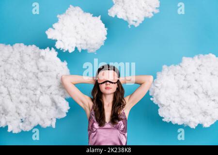 Portrait of attractive girl relaxing sleeping fluffy clouds flying isolated over bright blue color background Stock Photo