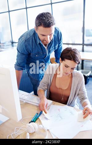 She needs a second opinion. High angle shot of two coworkers going through some papers together. Stock Photo
