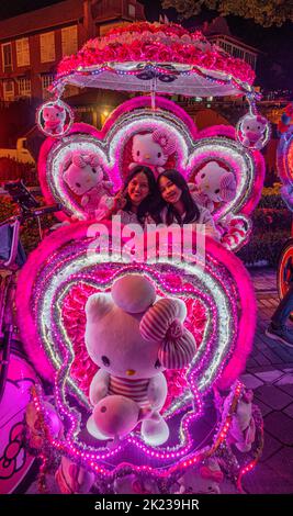 Malaysia, July 10, 2022 - Flashing neon lights on a tourist tricycle tour the rown. Stock Photo