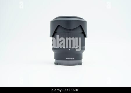 28-70mm camera interchangeable lens with front and rear lens cap and lens hood without manufacturer's mark on a white background Stock Photo
