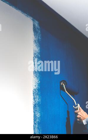 Painting a white wall in blue. Repair Stock Photo