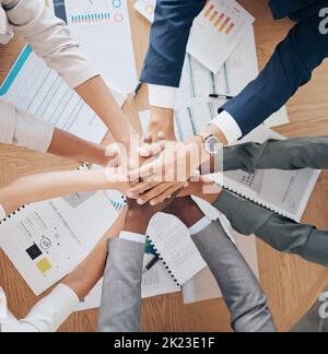 Team hands, collaboration and meeting of business people in agreement together above papers at work in the office. Group of employee hand in teamwork Stock Photo