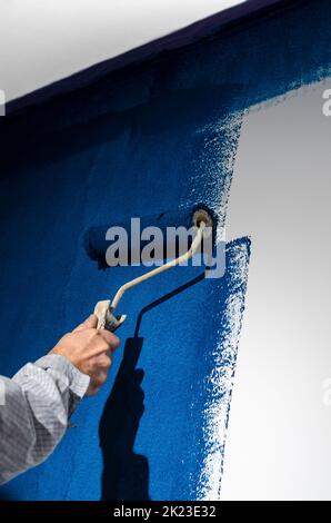 Painting a white wall in blue. Repair Stock Photo