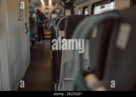 View of interior in a deserted empty commuter train carriage with rows of seats. Stock Photo