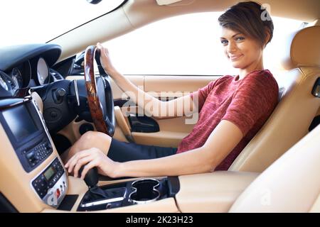 Its stick shift or nothing. a beautiful young woman driving a luxury car. Stock Photo