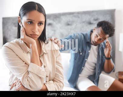 Couple fighting, sad woman ignore man who try stop conflict or divorce in home. Angry lady in bedroom, guy touch with hand wants communication or Stock Photo