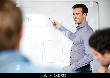 Where trending upwards. a man giving a whiteboard presentation to colleagues in an office. Stock Photo