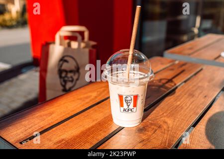 Krakow, Poland - September 11 2022: Plastic cup of ice coffee latte with KFC logo on table in fast food chain restaurant. Stock Photo