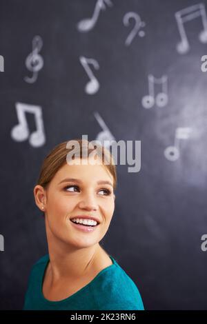 Using illustrations to teach her students. an attractive young woman standing in front of a blackboard. Stock Photo