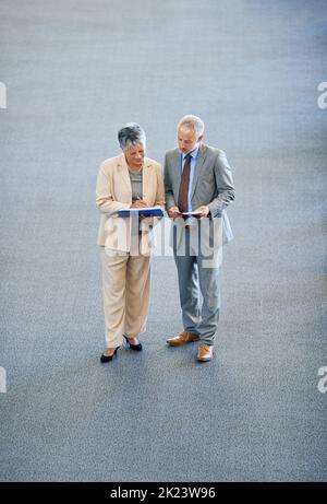 Years of combined business success between them. two mature businesspeople talking. Stock Photo