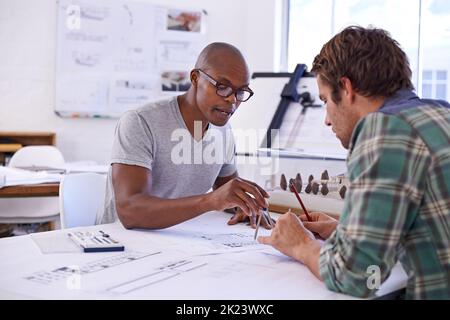 Skilled architects sketching away. two male architects working together on building plans. Stock Photo
