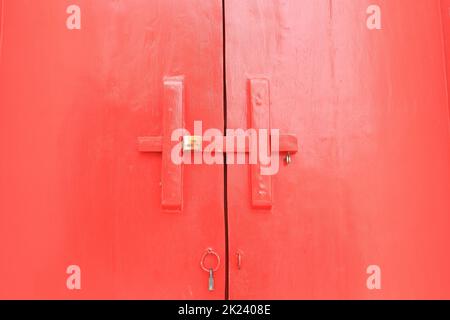 ancient timber bolt lock on a red wooden main gate. Stock Photo