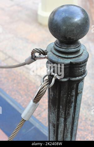 pole with metal restraining rope. Barrier, enclosed VIP area, protected entrance, private event, restrict area barricade pole. Stock Photo