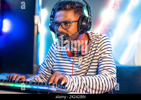 Excitement gamer with headphones playing online video game on computer by talking at home - concept of tournament, relaxation and technology Stock Photo