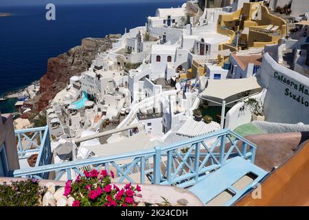 Oia, Santorini, Greece - July 3, 2021: Whitewashed houses with terraces and pools and a beautiful view in Oia on Santorini island, Greece Stock Photo