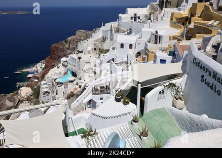 Oia, Santorini, Greece - July 3, 2021: Whitewashed houses with terraces and pools and a beautiful view in Oia on Santorini island, Greece Stock Photo