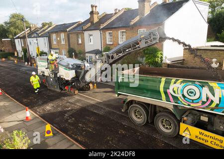 Mechanised removal of the old road surface prior to resurfacing of a residential Street in Twickenham, Greater London, UK. It will be resurfaced with tarmac after the previous worn and potholed asphalt has been removed. (132) Stock Photo