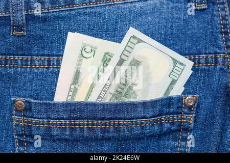 Dollars stick out of the pocket of jeans. Money in your pocket. Stock Photo