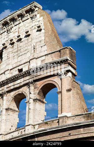 Rome, Italy. Arches archictecture of Colosseum (Colosseo) exterior with blue sky background and clouds. Stock Photo