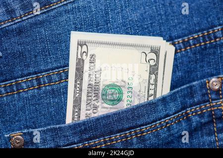 Dollars stick out of the pocket of jeans. Money in your pocket. Stock Photo
