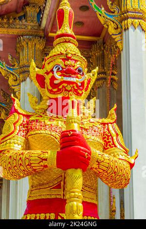 Giant temple guardian Yaksha in gold red at colorful Wat Don Mueang Phra Arramluang buddhist temple in Bangkok Thailand. Stock Photo