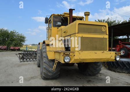 Russia, Temryuk - 15 July 2015: Big yellow tractor. Old Soviet agricultural machinery Stock Photo