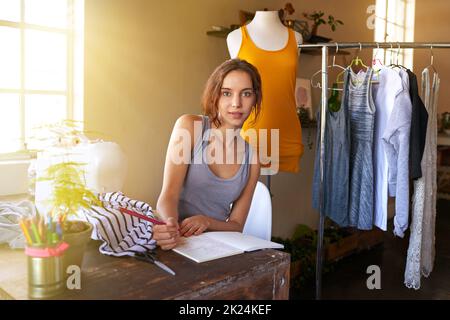 Choose a job you love. A young designer making a garment in her workplace. Stock Photo