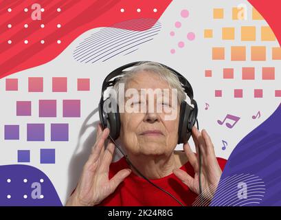 Funny old woman in headphones listening to music Stock Photo