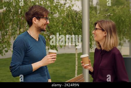 Smiling caucasian businesswoman and man Funny Coversation talking. Coworkers friendly discussion during lunch time. Confident Employees. Stock Photo