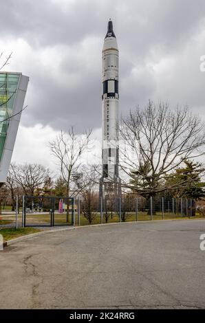 United States Rocket standing at New York Hall Of Science, with way and fence in front, Queens, New York City during overcast winter day, vertical Stock Photo