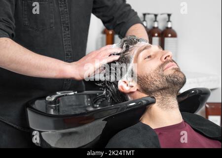 Barber shop. Hairdresser man washes client head in barbershop. High quality photography Stock Photo