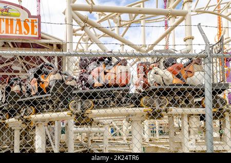 Steeplechase Coaster closed, empty at Luna Park Amusement Park with fence in front, Coney island, Brooklyn, New York City during winter day with cloud Stock Photo