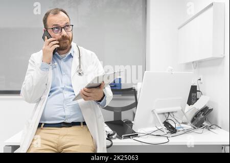 Thoughtful male doctor using digital tablet thinking of medical problem solution. High quality photography Stock Photo