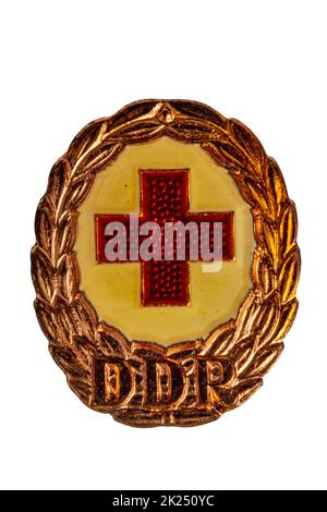 Potsdam, Germany - MAY 06, 2022. Badges, orders and medals from GDR (DDR). Close-up of a National Defence Badge of the German Red Cross in bronze. Cli Stock Photo