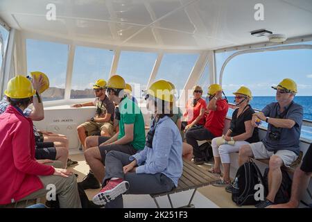 White Island, New Zealand - Circa 2016: Volcanic tour, group on the boat ride prepared with gas masks against sulfuric fumes. Tours landing on the isl Stock Photo