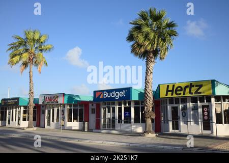 ORANJESTAD, ARUBA - DECEMBER 21, 2020: Car rental offices early in the morning outside the Queen Beatrix International Airport in Oranjestad on the Ca Stock Photo