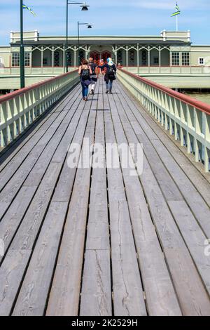 Malmo, Sweden - June 24, 2019:  Ribersborgs open-air bath also known as Ribban, wooden pier with walking people. The historic building is located in t Stock Photo