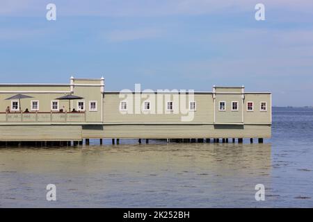 Malmo, Sweden - June 24, 2019:  Ribersborgs open-air bath also known as Ribban, people sitting on the terrace. The historic building is located in the Stock Photo