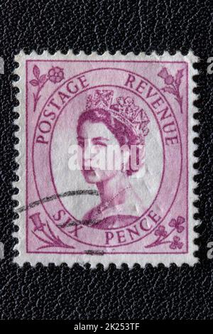 Potsdam, Germany - APR 26, 2022. A old of Great Britain (United Kingdom) issued stamp with portrait of Queen Elizabeth II with postmark on a black lea Stock Photo