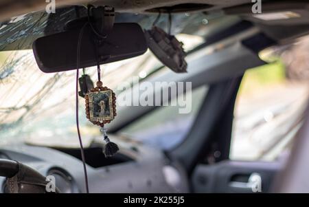 Broken car windshield from a bullet, inside view. Damaged glass with traces of an oncoming stone on the road. Interior view of the car. Translation: S Stock Photo