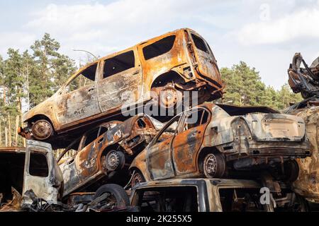 A lot of rusty burnt cars in Irpen, after being shot by the Russian military. Russia's war against Ukraine. Cemetery of destroyed cars of civilians wh Stock Photo