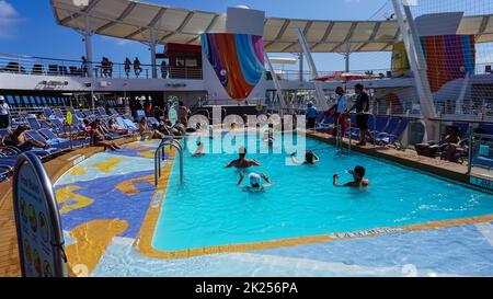 Miami, USA - April 29, 2022: The people playing at pool at upper deck in mini volleyball at cruise liner or ship Symphony of the Seas by Royal Caribbe Stock Photo